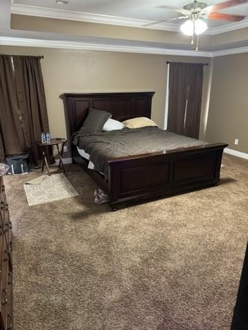 carpeted bedroom with ornamental molding, ceiling fan, and a raised ceiling