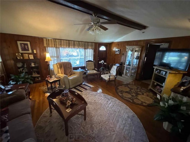 living room with vaulted ceiling with beams, wood walls, a ceiling fan, and wood finished floors