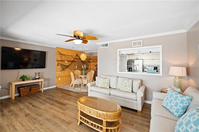1051 Beach Blvd, Gulf Shores, AL 36542 - living room featuring ornamental molding, a ceiling fan, and wood finished floors