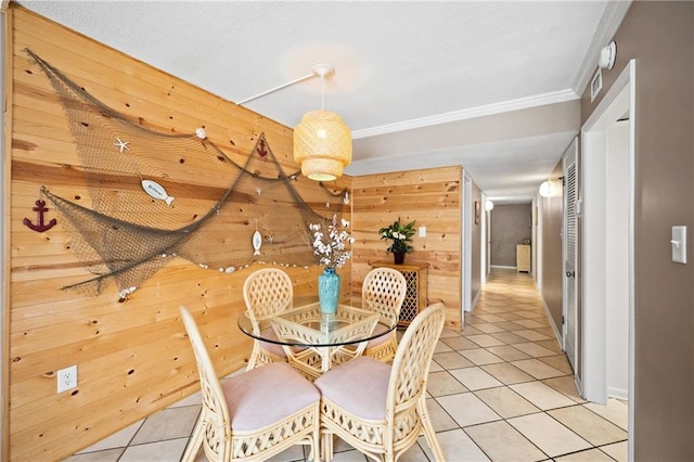 1051 Beach Blvd, Gulf Shores, AL 36542 - dining area with wood walls, light tile patterned flooring, and crown molding