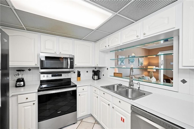 1051 Beach Blvd, Gulf Shores, AL 36542 - kitchen with stainless steel appliances, backsplash, white cabinetry, and light countertops