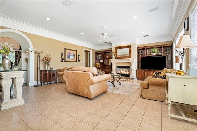2924 Riverview Pointe Dr S, Theodore, AL 36582 - living area featuring a glass covered fireplace, light tile patterned floors, a ceiling fan, ornamental molding, and arched walkways