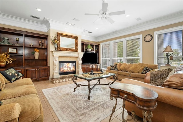 2924 Riverview Pointe Dr S, Theodore, AL 36582 - living room featuring light tile patterned floors, a ceiling fan, healthy amount of natural light, a glass covered fireplace, and crown molding