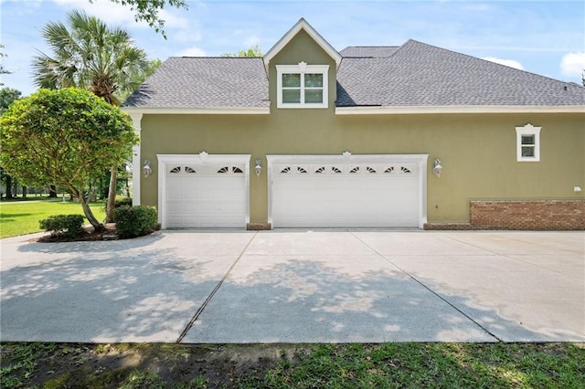 2924 Riverview Pointe Dr S, Theodore, AL 36582 - view of side of property featuring stucco siding, driveway, an attached garage, and roof with shingles