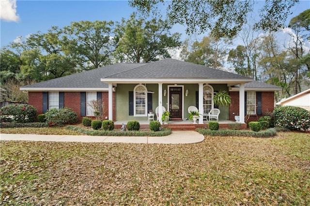 ranch-style home with covered porch and a front yard