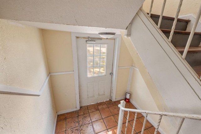 doorway to outside with a textured ceiling