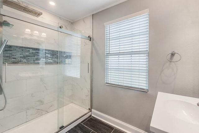 bathroom featuring an enclosed shower, vanity, and a healthy amount of sunlight