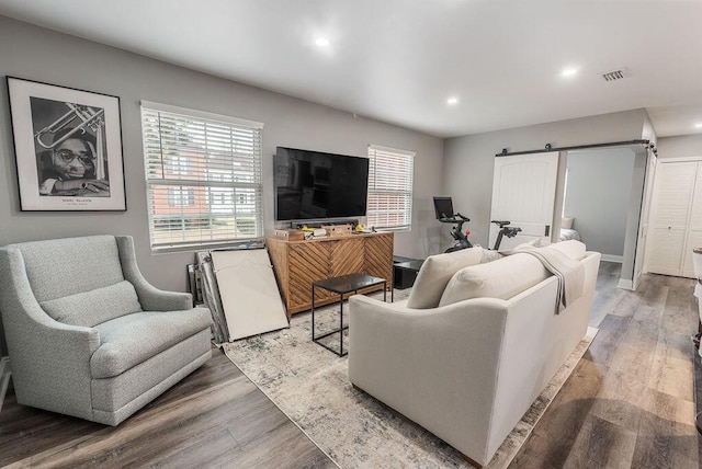 living room with light hardwood / wood-style floors and a barn door