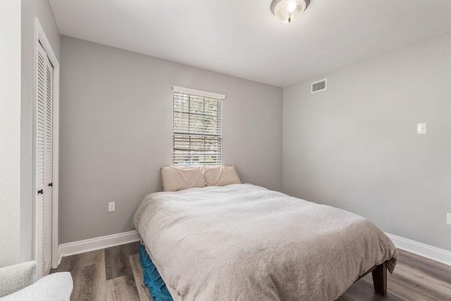 bedroom featuring dark wood-type flooring and a closet