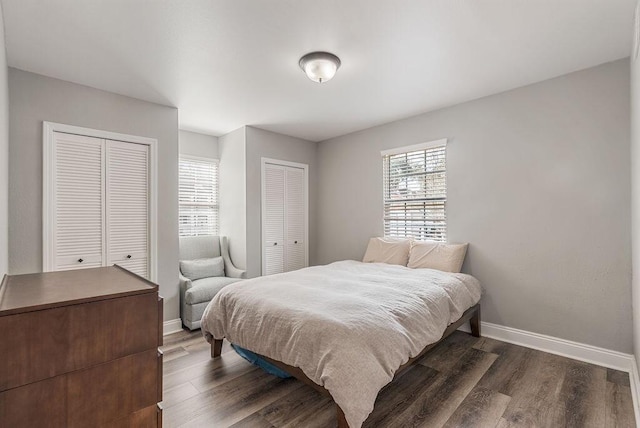 bedroom featuring two closets and dark wood-type flooring