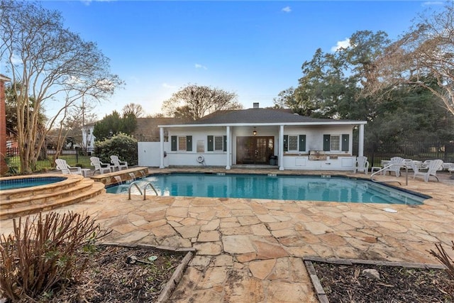 view of pool featuring pool water feature, a patio, and an in ground hot tub