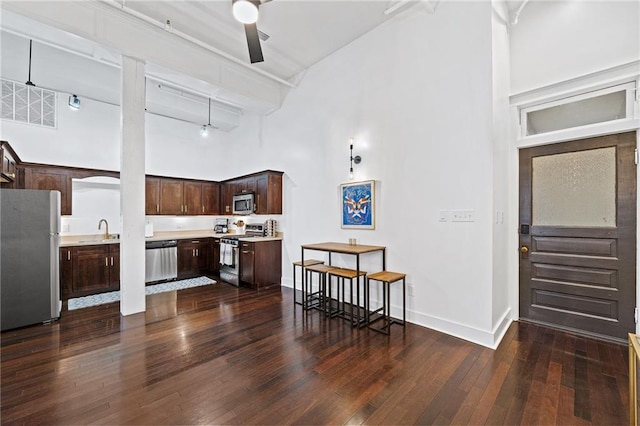 204 Conti St Unit 1A, Mobile, AL 36602 - kitchen featuring stainless steel appliances, a towering ceiling, dark brown cabinets, light countertops, and dark wood-type flooring
