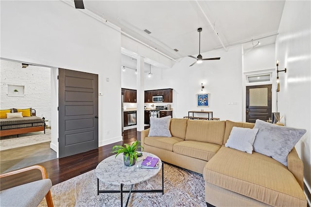204 Conti St Unit 1A, Mobile, AL 36602 - living room featuring ceiling fan, a towering ceiling, wood finished floors, and rail lighting