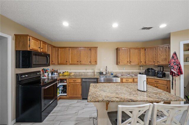 18141 Pennsylvania St, Robertsdale, AL 36567 - kitchen with black appliances, visible vents, a breakfast bar area, marble finish floor, and a sink