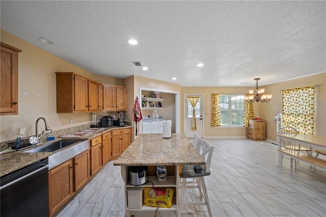 18141 Pennsylvania St, Robertsdale, AL 36567 - kitchen with black dishwasher, brown cabinets, a textured ceiling, and washer and clothes dryer