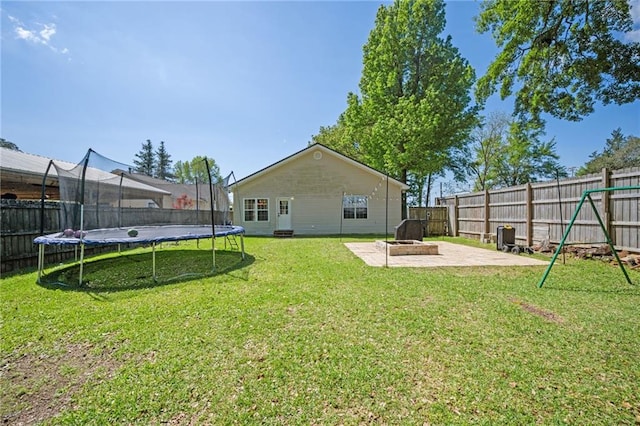 18141 Pennsylvania St, Robertsdale, AL 36567 - view of yard featuring a fenced backyard, a trampoline, an outdoor fire pit, and a patio