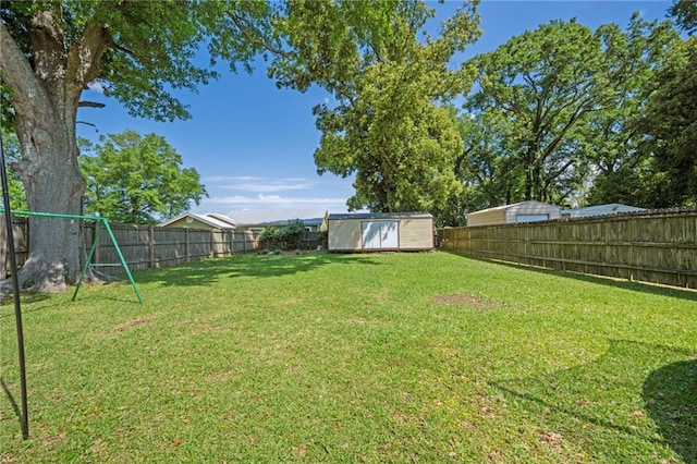 18141 Pennsylvania St, Robertsdale, AL 36567 - view of yard with a storage shed, a fenced backyard, a playground, and an outdoor structure