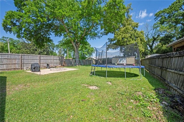 18141 Pennsylvania St, Robertsdale, AL 36567 - view of yard featuring a trampoline, a patio area, and a fenced backyard
