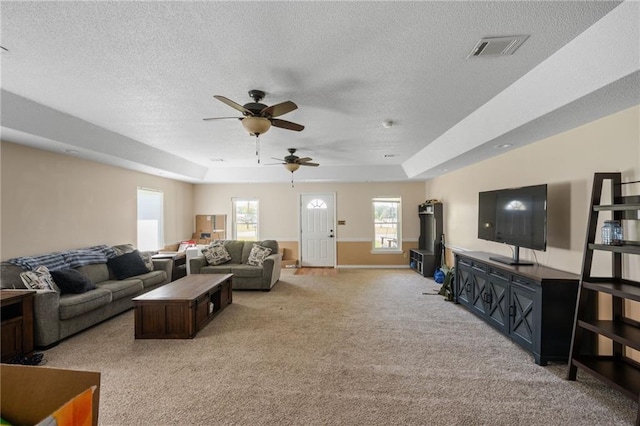 18141 Pennsylvania St, Robertsdale, AL 36567 - living room featuring a textured ceiling, a ceiling fan, visible vents, light carpet, and a raised ceiling