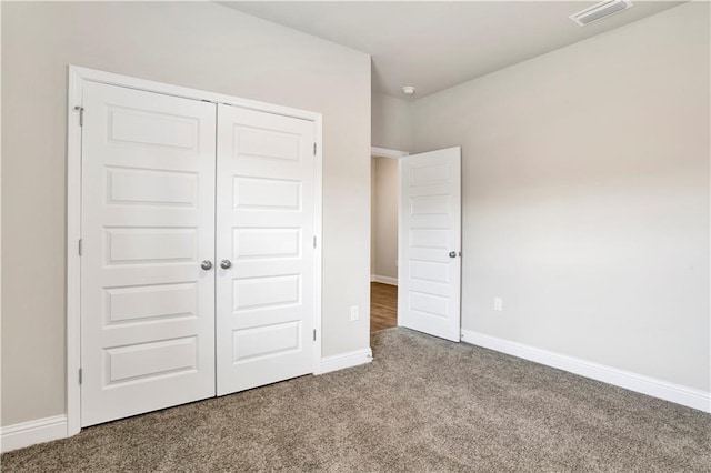 unfurnished bedroom with light carpet and a closet