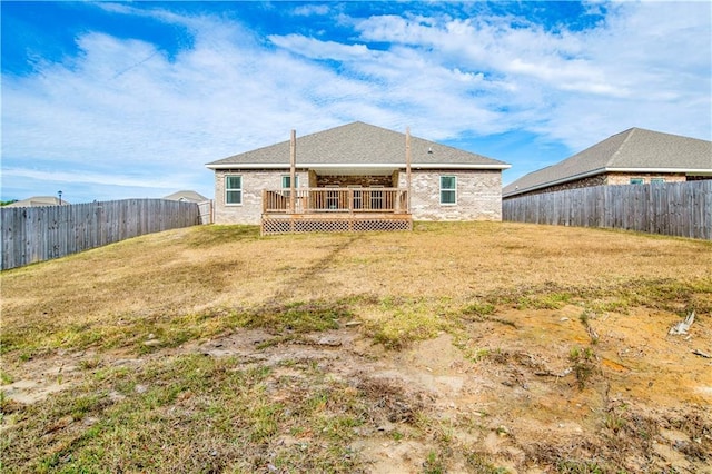 back of property with a yard and a wooden deck