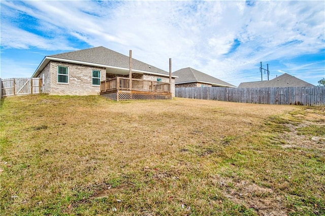 back of house with a lawn and a wooden deck