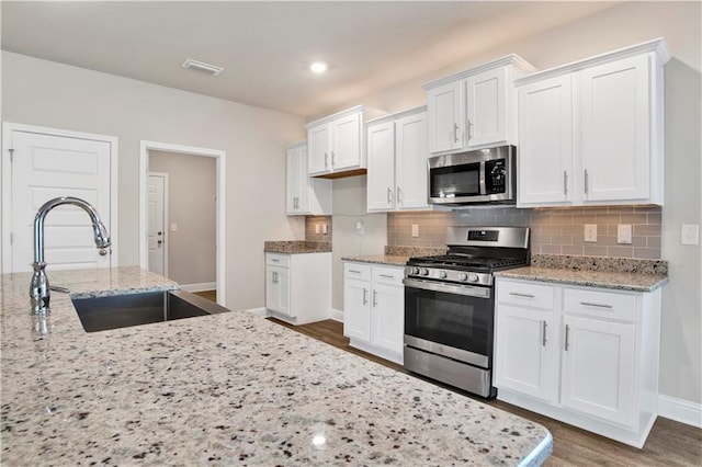 kitchen with white cabinets, sink, stainless steel appliances, and dark wood-type flooring