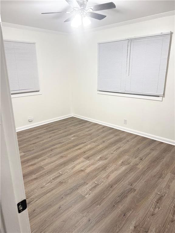 empty room featuring ceiling fan, ornamental molding, and wood finished floors