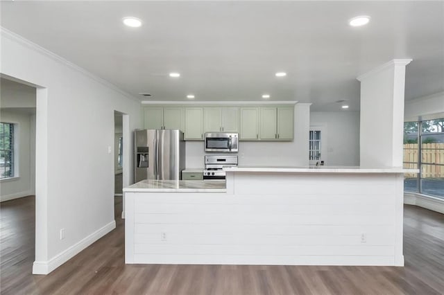 kitchen featuring stainless steel appliances, ornamental molding, and hardwood / wood-style floors