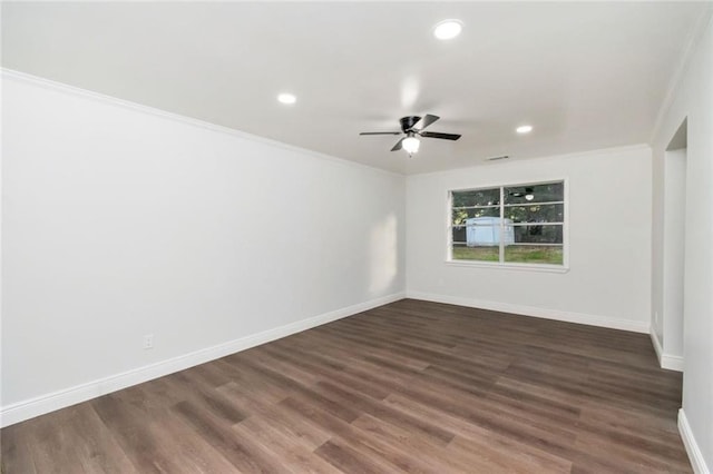 empty room featuring crown molding, dark hardwood / wood-style floors, and ceiling fan