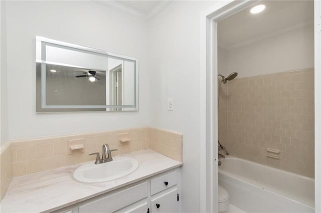 full bathroom featuring vanity, toilet, ornamental molding, and tiled shower / bath