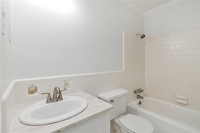 full bathroom with vanity, toilet, tiled shower / bath combo, and tile walls