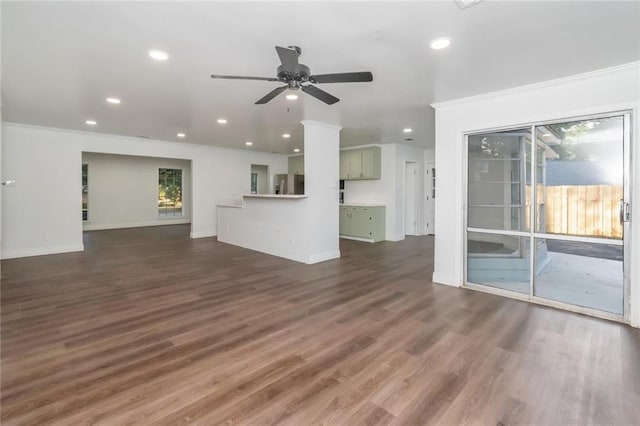 unfurnished living room with ornamental molding, ceiling fan, and dark hardwood / wood-style flooring