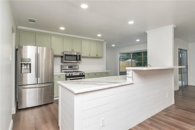 kitchen featuring dark wood-type flooring, light stone counters, stainless steel appliances, and green cabinets