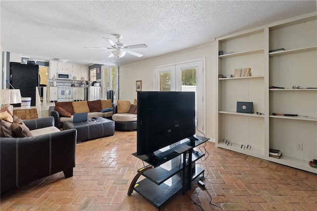 living room with built in features, a textured ceiling, ceiling fan, and french doors