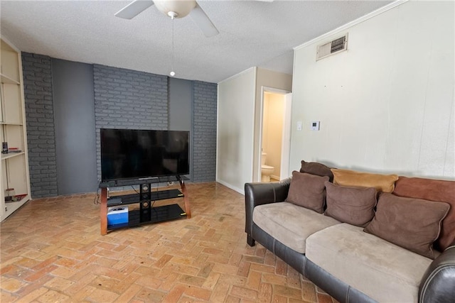 living room featuring brick wall, a textured ceiling, and ceiling fan