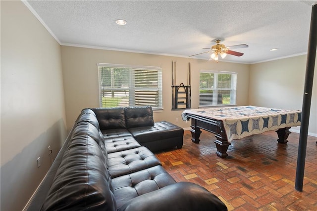 recreation room featuring a textured ceiling, ceiling fan, crown molding, and billiards