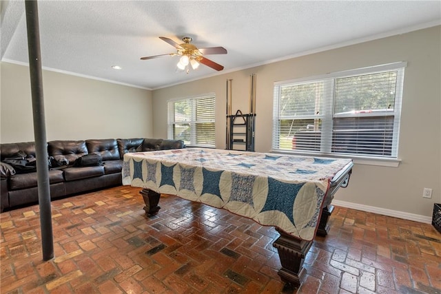 playroom featuring ornamental molding, a textured ceiling, and ceiling fan