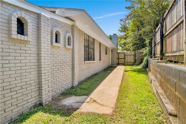 2604 Old Dobbin Dr E, Mobile, AL 36695 - view of side of home with brick siding and a gate