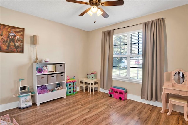 game room featuring ceiling fan, wood finished floors, and baseboards