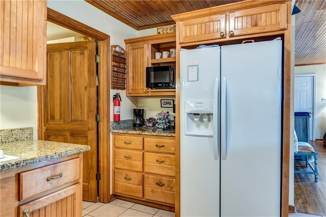 2012 Bienville Blvd, Dauphin Island, AL 36528 - kitchen featuring white fridge with ice dispenser, black microwave, crown molding, light stone counters, and open shelves