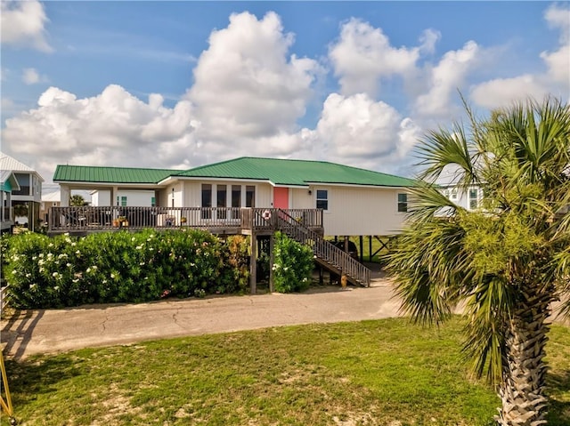 2012 Bienville Blvd, Dauphin Island, AL 36528 - back of house with stairway, a metal roof, a lawn, and driveway