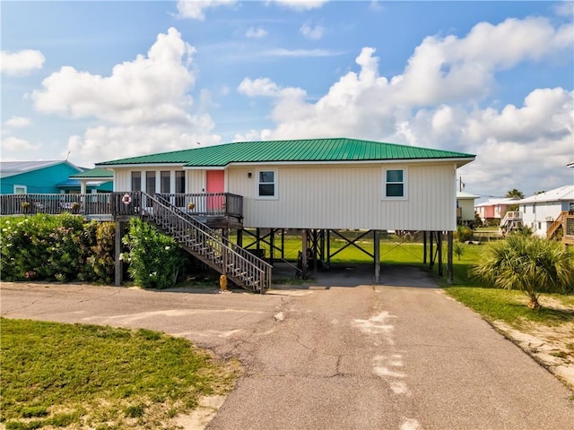 2012 Bienville Blvd, Dauphin Island, AL 36528 - coastal inspired home featuring asphalt driveway, a carport, stairs, a metal roof, and a front lawn