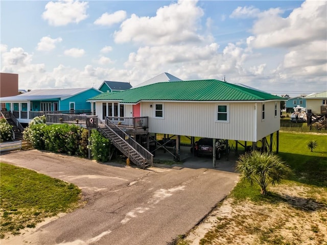 2012 Bienville Blvd, Dauphin Island, AL 36528 - raised beach house with driveway, stairway, a carport, and a metal roof