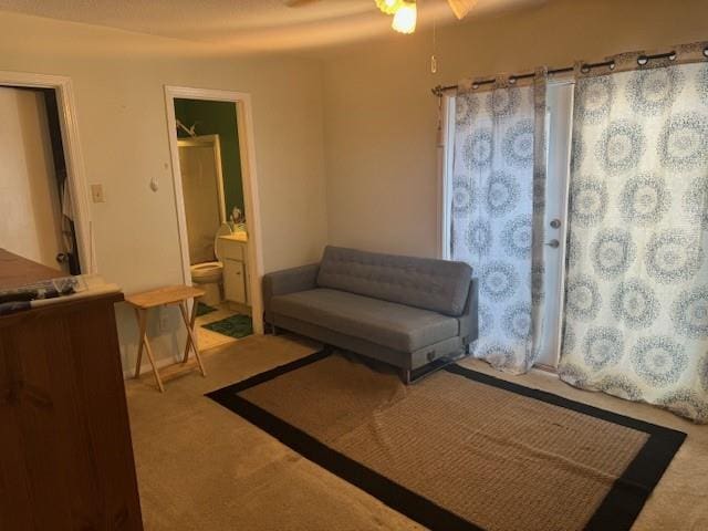 living area with carpet and ceiling fan