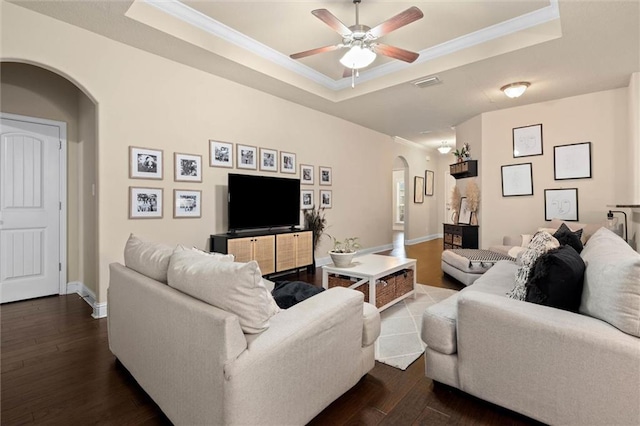 6120 Whitebark Dr, Mobile, AL 36693 - living room featuring arched walkways, a tray ceiling, a ceiling fan, dark wood-style flooring, and crown molding
