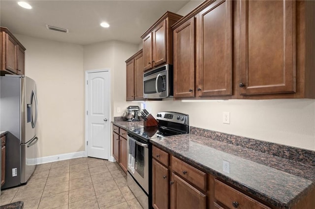6120 Whitebark Dr, Mobile, AL 36693 - kitchen featuring appliances with stainless steel finishes, baseboards, recessed lighting, dark stone countertops, and light tile patterned flooring