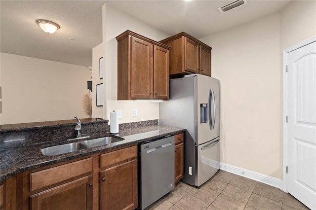 6120 Whitebark Dr, Mobile, AL 36693 - kitchen with appliances with stainless steel finishes, a sink, dark stone countertops, light tile patterned flooring, and baseboards