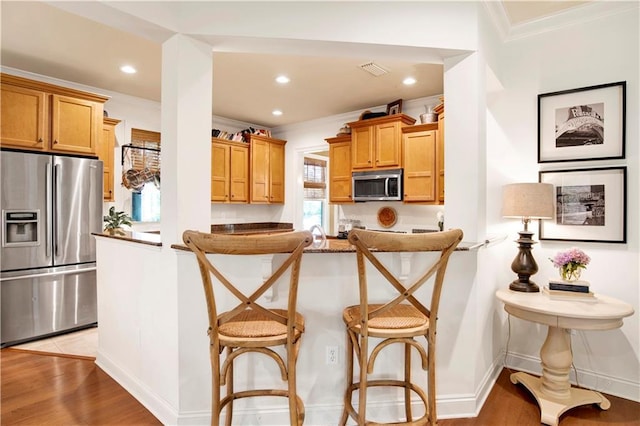 24795 Austin Rd, Daphne, AL 36526 - kitchen featuring stainless steel appliances, a breakfast bar area, ornamental molding, light wood-type flooring, and recessed lighting