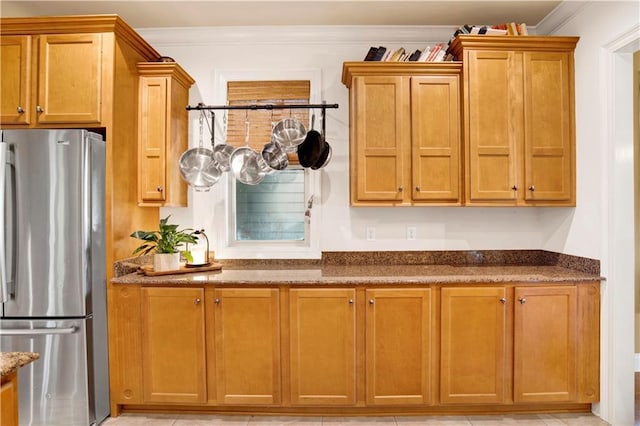 24795 Austin Rd, Daphne, AL 36526 - kitchen featuring freestanding refrigerator, dark stone countertops, ornamental molding, and brown cabinets